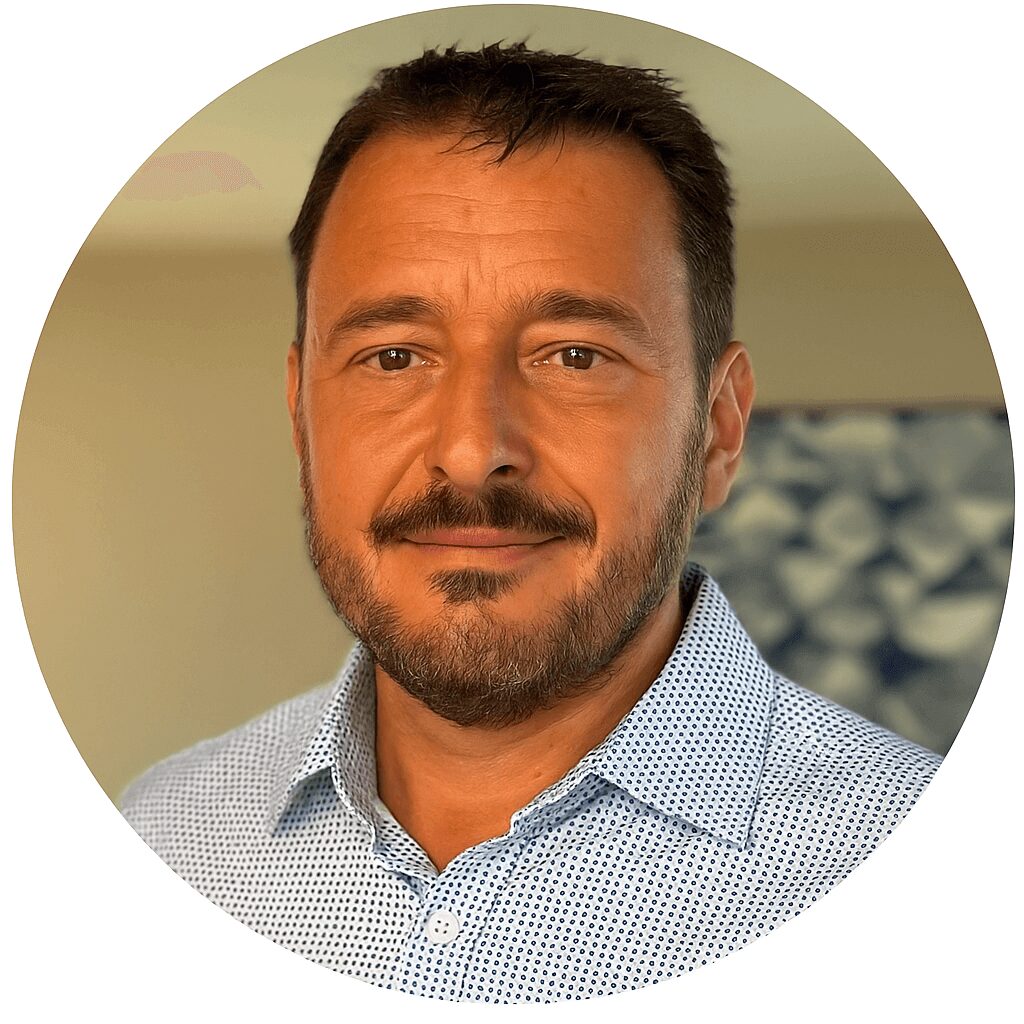 Professional headshot of a smiling man in a blue shirt.